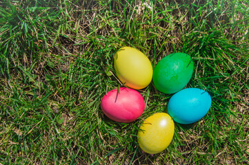 Top view of a bunch of colorful Easter eggs laid out on the green spring grass. Flat style, Easter holiday concept