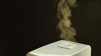 Humidifier making hot steam to increase humidity during dry winter weather. Indoor steam humidifier for use in bedroom or living room at home for better indoor climate environment and air quality