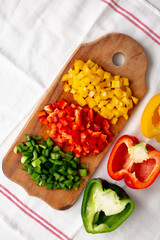 Chopped Fresh Colored Peppers on a Rustic Wooden Board, top view. Flat lay, overhead, from above. Copy space.