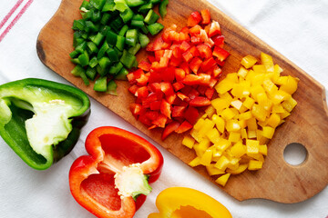 Chopped Fresh Colored Peppers on a Rustic Wooden Board, top view. Flat lay, overhead, from above.