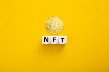 NFT wording with Bitcoin on yellow background