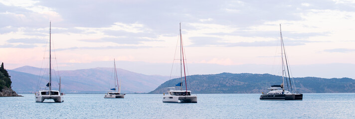 Mediterranean bay with sailing boats catamarans panoramic banner. Yachts on the sea, Corfu island,...