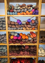 wool yarn threads, colored yarn skeins arranged on shelves, knitting as a hobby
