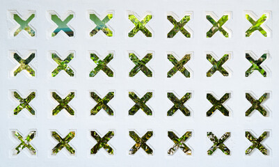 White wall designd in cross hole pattern, concrete blocks wall in the garden