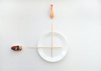 Sushi time concept - white plate and chopsticks as clock with nigiri sushi isolated on white.Concept time for sushi - nigiri and unagi sushi japan food on white with white plate and chopsticks.