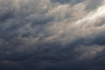 Dark gray heavy clouds in the sky before a thunderstorm. Dramatic spectacular backdrop or wallpaper. Natural grim menacing background. Ahead of a storm or cataclysm. Beastly nasty weather. Overcast