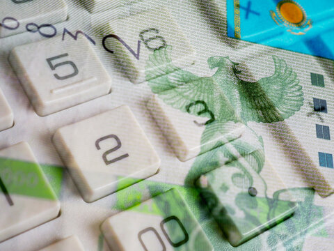 Kazakh paper money. Fragment of 2000 tenge bill and calculator button closeup. Economic calculation and investment. Credit and interest. Savings in Kazakhstan. Bird Samruk on Kazakh tenge. Macro