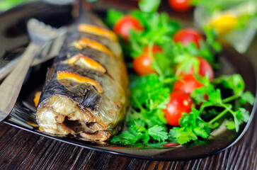 Mackerel baked with lemon. Fish on a plate with vegetables