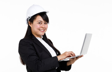 Portrait studio cutout isolated closeup shot Asian young female engineer architect in formal suit with safety hardhat helmet smiling look at camera holding typing laptop computer on white background