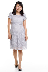 Portrait studio cutout isolated full body shot of Asian young happy trendy female model in beautiful gray lace dress standing posing holding hand on waist smiling look at camera on white background