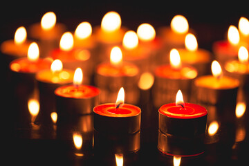 candle,Many candles burn with a shallow depth of field,Burning candles in darkness