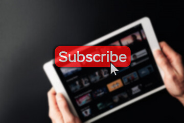 Subscription icon. Online video red subscribe button. Internet service on laptop digital tablet blured technology background. Social media concept. Streaming video.