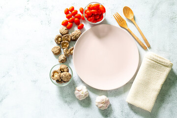 plates and ingredients,Healthy food. Vegetables, lemon and chickpeas around empty white plate on a concrete background, top view, free space for text. Vegetarian and vegan food concept, copy space, fl