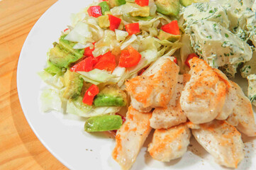 Stewed chiken with boiled potato on the plate.