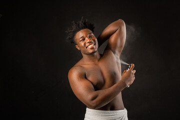 adult african man with athletic build with deodorant on black background 