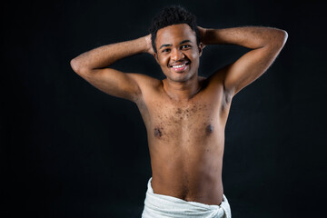 Fototapeta premium portrait of young african shirtless man on black background