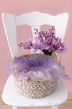 Shoot set up with flowers, basket for newborn on the white chair. Photo zone for a photo session of newborns. Setup ready for newborn photo shoot and baby photography. Spring. 