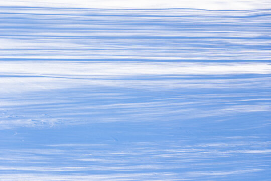 Winter background with blue parallel shadows on snow