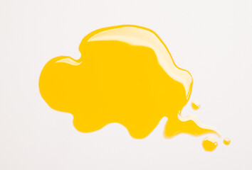 Cosmetics oil drops yellow liquid spot splash drop on white background copy space.