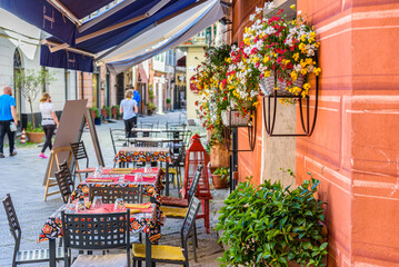 Fototapeta na wymiar Finalborgo, Finale Ligure, Italy. May 5, 2021. Tables outside a restaurant in Piazza Garibaldi.
