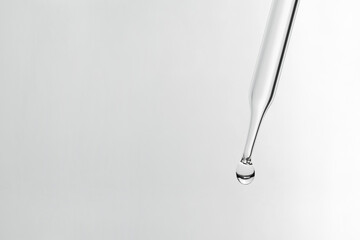 Liquid drop from laboratory glass Pipette on background