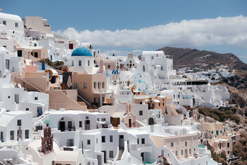 Fototapeta na wymiar View of Oia town with church and blue dome in Santorini island in Greece. Summer vacation and holiday concept, luxury travel. Wonderful scenery, cruise ships and white architecture. Amazing landscape