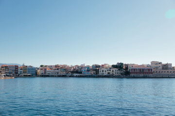 Panorama of colorful buildings and seascape in Chania town on Crete island, Greece. Copy space. Old Venetian harbour of Chania at sunny day with blue sky and water and space for text.