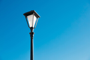 Lonely street lamp on a blue sky background, black and white color, isolated, with space for text, copy space. City Chania, island Crete, Greece. .