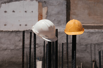 Two helmets white and orange left by the workers at a construction site with stone wall background in island Crete. Hard work in Corona time, Covid-19, virus. Construction protective dirty helmets