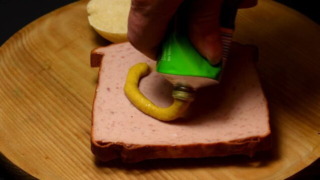 putting mustard on a Bavarian Leberkaese