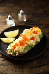 Healthy avocado toast with scrambled eggs and caviar