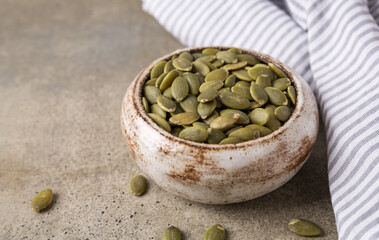 Pumpkin seeds in a bowl, superfoods. Copy space