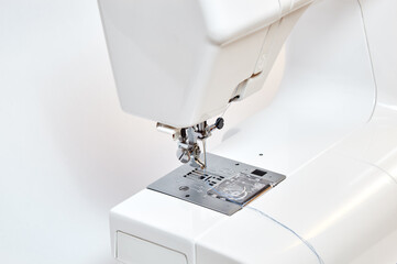 Sewing machine working part, replacement foot. Sewing machine with thread, closeup