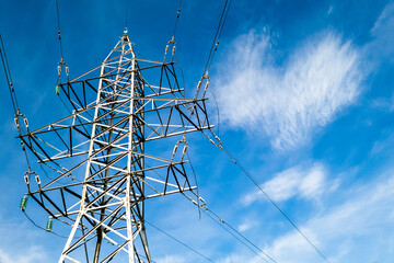 Electrical high voltage tower with wires on a cloudy blue sky background at sunny day