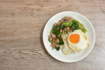 spicy stir fried Chinese kale with pork topping egg on rice