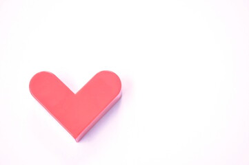 red plastic heart shape arranging on white background
