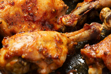 roasted chicken legs with aromatic crust, baked meat on a oven tray, tasty food close view