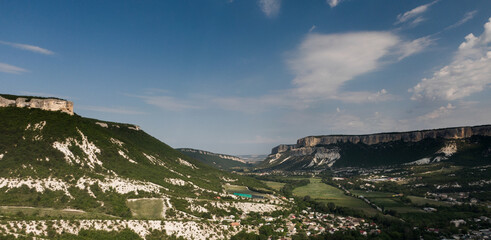 A soothing, majestic landscape. Crimean Grand Canyon with a village in the valley. A bright sunny day
