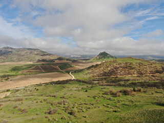 Naklejka premium Peaceful landscape of vineyards among the mountains under a cloudy sky