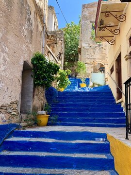 Fototapeta Symi main town street view. Cozy small greek island in Dodecanese group in Aegean sea. Colorful streets of old medieval town. Staircase to upper streets. Old town street view of Ano Symi. Cobbled stre