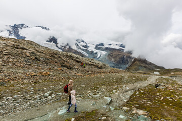 Mother and to children going for a walk in mountain surroundings