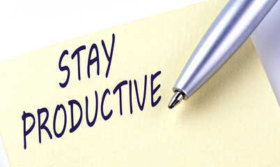 Sticky Note Message STAY PRODUCTIVE with pen on white background