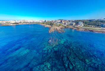 Panoramic view of Alghero rocky shore on a sunny day