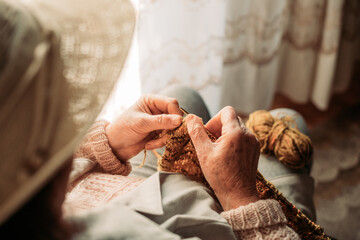 Close-up of elderly woman hands knitting. Wintertime