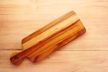 wooden chopping board on wooden background top down 