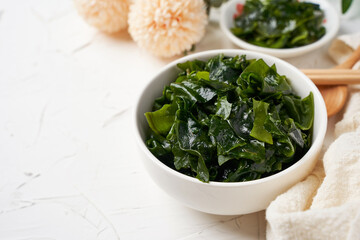 close up laminaria (Kelp) seaweed in bowl on white table background                        with copy space                                                     © boommaval