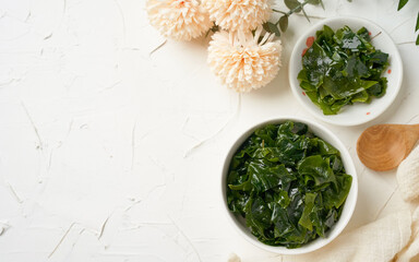 Obraz na płótnie Canvas Top view laminaria (Kelp) seaweed and spirulina powder in white bowl background 