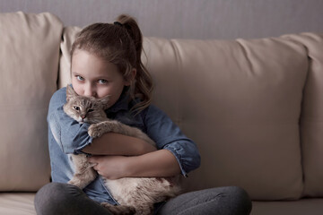 girl with kitten sitting on the sofa