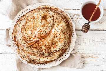 Stack of traditional russian pancakes blini on wooden background. Maslenitsa traditional Russian...