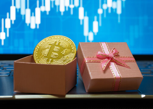 Bitcoin BTC cryptocurrency in a gift box with a stock trading background, gold coin as a symbol of electronic virtual money for web banking and international network payment